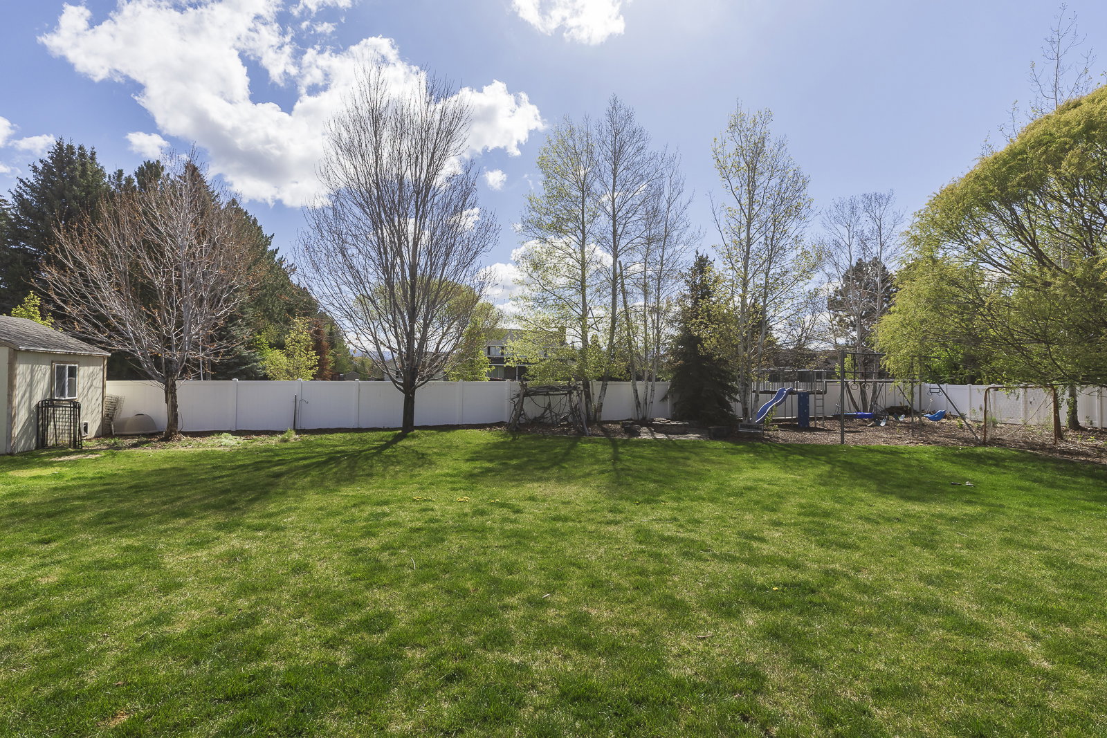 Fenced backyard featuring a playground