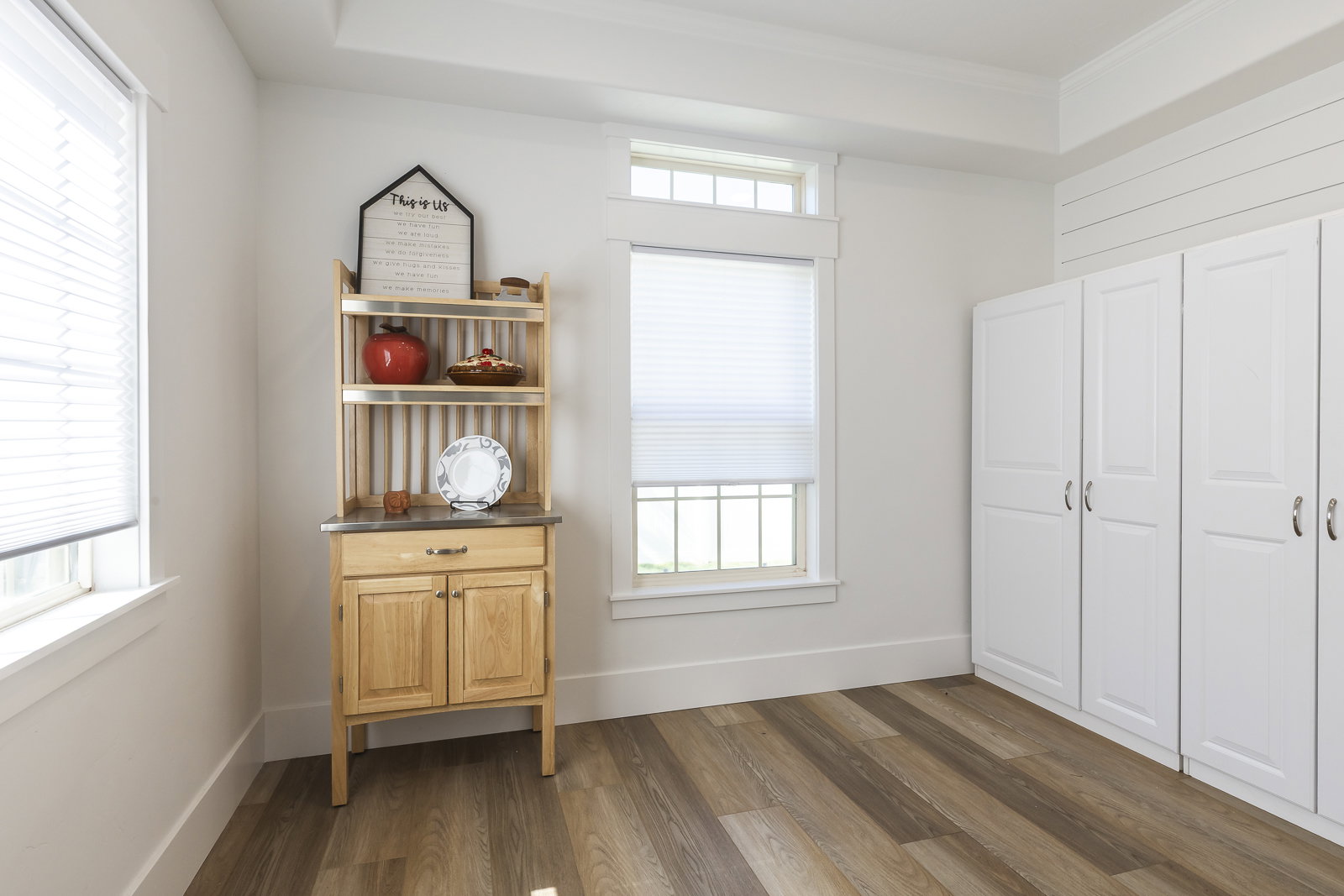 Sitting room with dark wood-style flooring and crown molding
