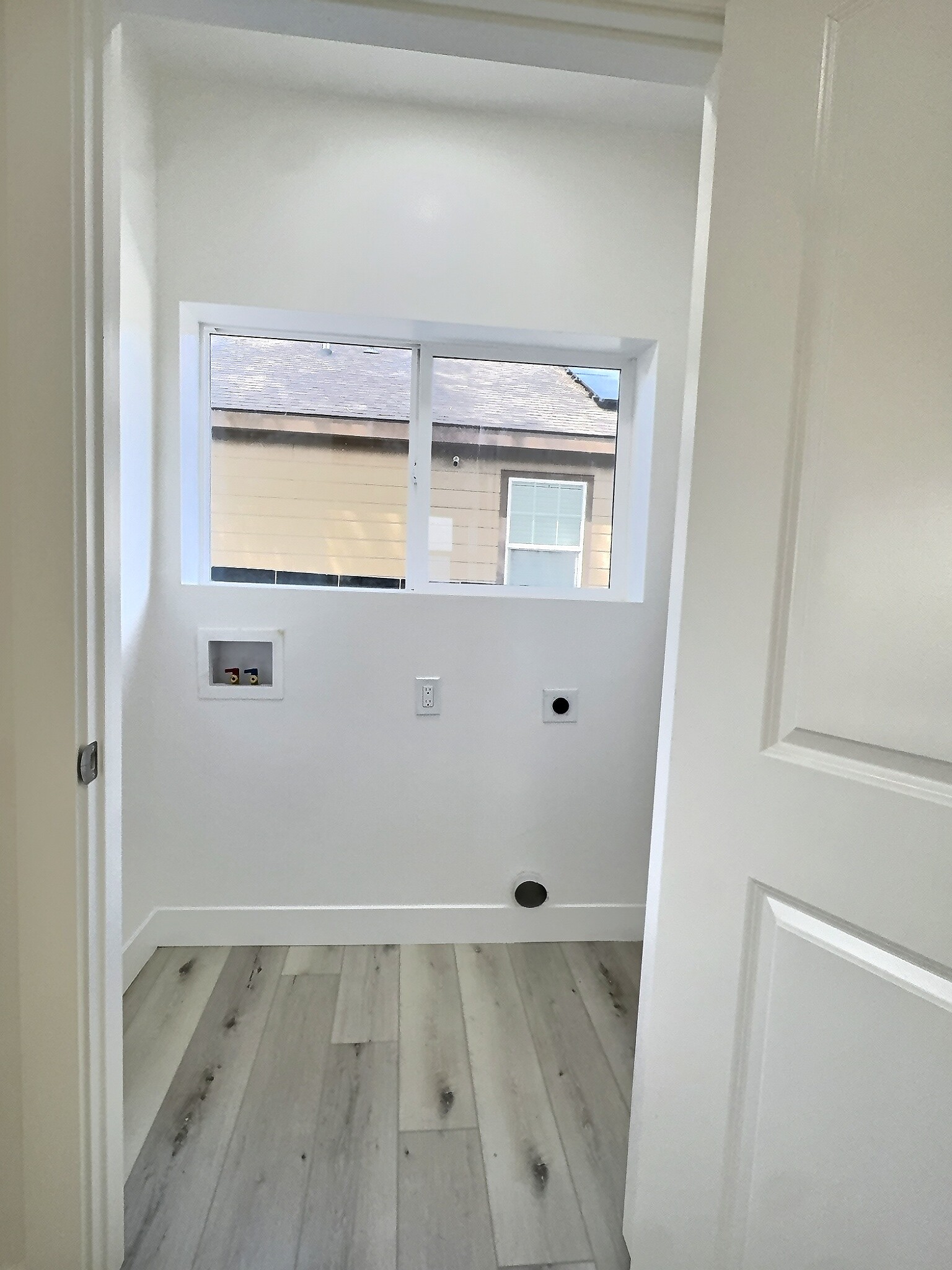 Laundry area with light wood-style flooring, washer hookup, and hookup for an electric dryer