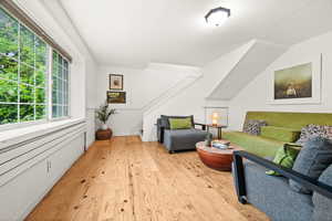 Living area with light wood finished floors picture window and stairs to second level