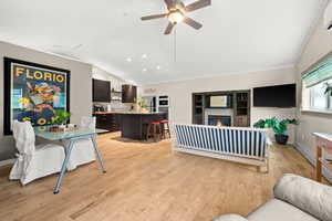 Above garage one bedroom apartment featuring lofted ceiling, a ceiling fan, a gas fireplace, light wood-style floors, open kitchen with granite island breakfast bar