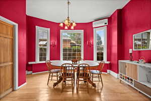 Formal dining room featuring large windows, light wood flooring