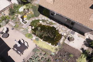 View of subject property featuring a garden pond and patio