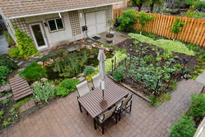 View of yard featuring a garden, fruit trees, a patio, outdoor dining area, and a koi pond and new fence
