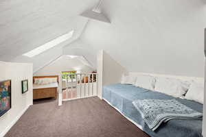 Freshly painted upstairs bedroom featuring carpet floors and a skylight