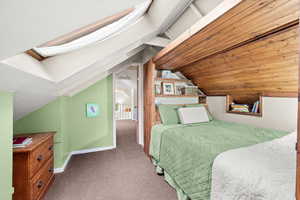 Upstairs bedroom featuring a skylight and built in bed with shelves