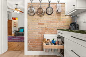 Kitchen with custom white cabinets and exposed brick wall