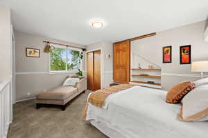 Upstairs bedroom featuring a closet, carpet, and a barn door and north, east and south facing windows for lots of natural light and a mini split for independent heating  and cooling