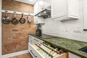 Kitchen with induction cooktop, vent hood that vents outside and custom cabinets