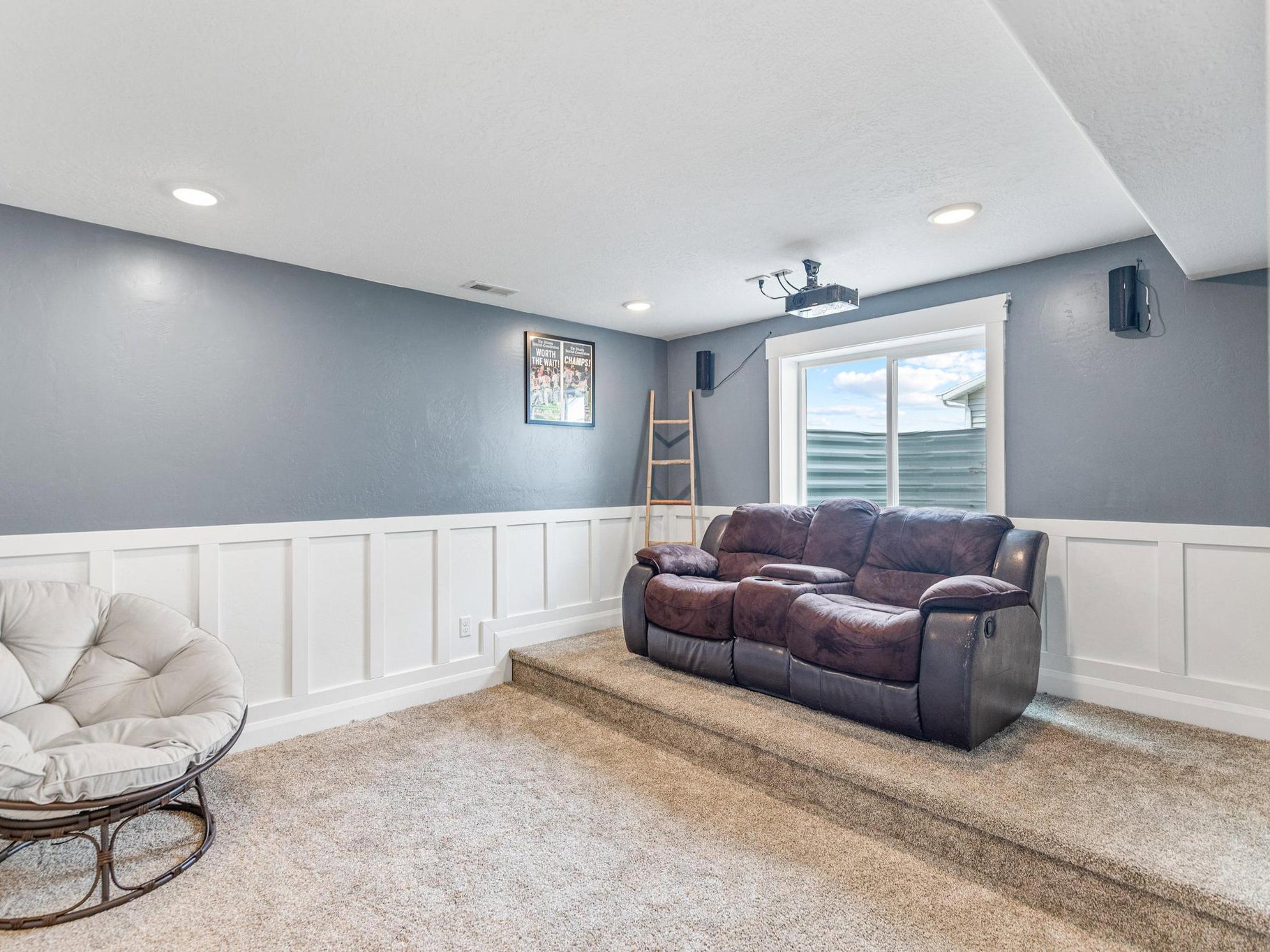 Living area featuring a decorative wall, wainscoting, carpet floors, and recessed lighting