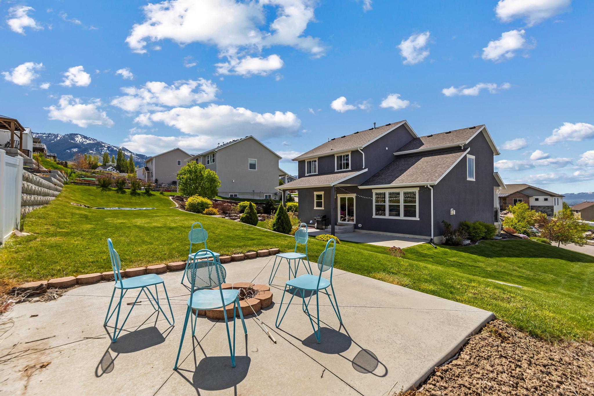 Back of house featuring a patio area, a residential view, a fire pit, and roof with shingles