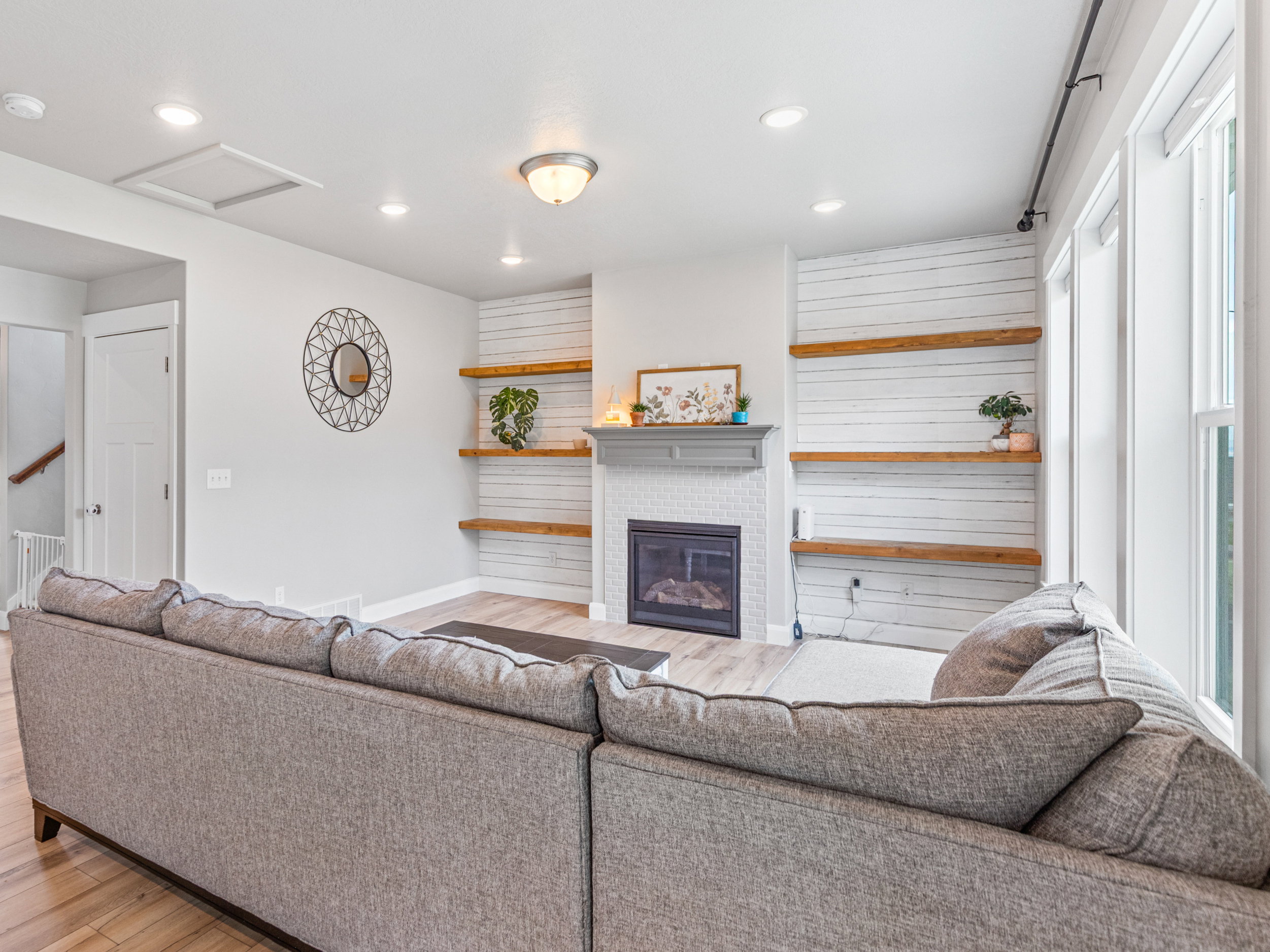 Living area with light wood finished floors, a fireplace with flush hearth, and recessed lighting