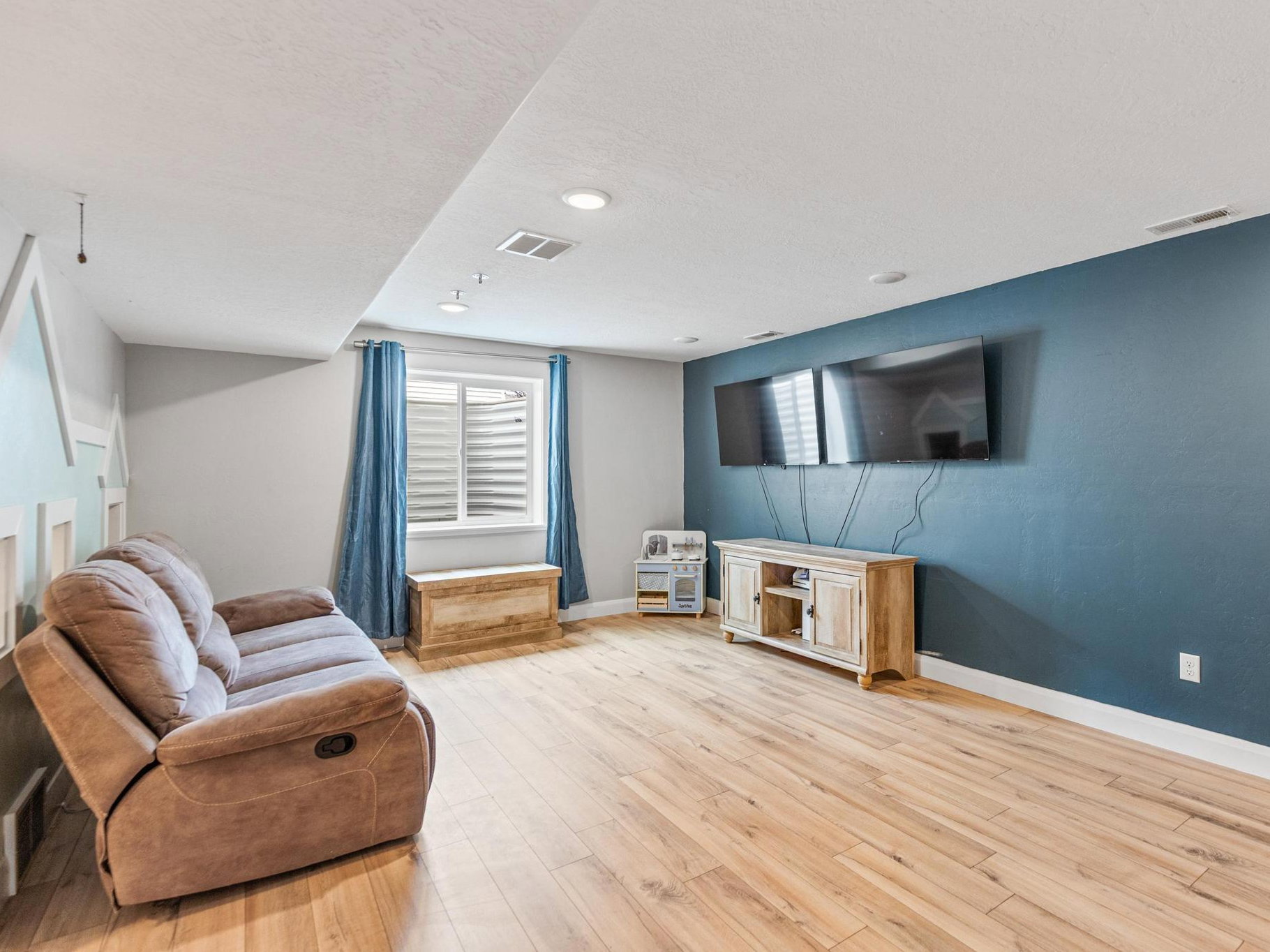 Living area with light wood-type flooring and a textured ceiling