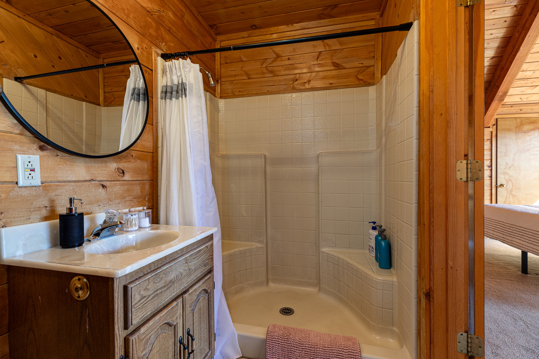 Full bath featuring vanity, a shower stall, wooden ceiling, and wooden walls