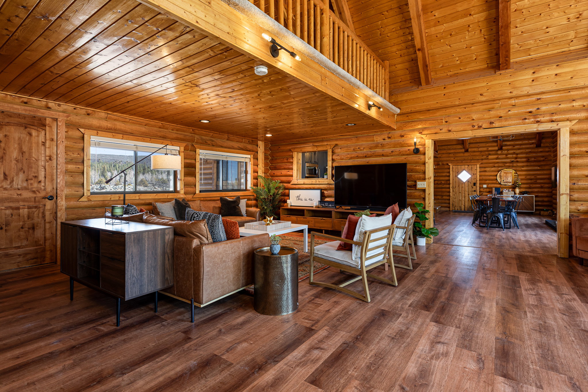 Living area featuring a high wooden beamed ceiling, rustic walls, and hardwood / wood-style flooring