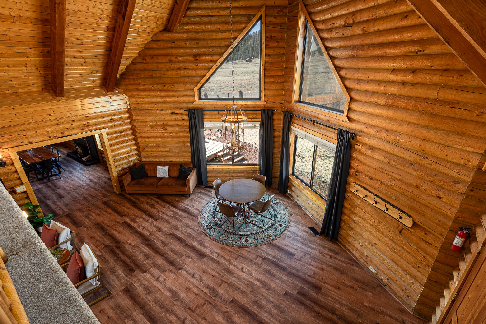 Living room featuring wood-type flooring, rustic walls, a high wood beamed ceiling, and a fireplace