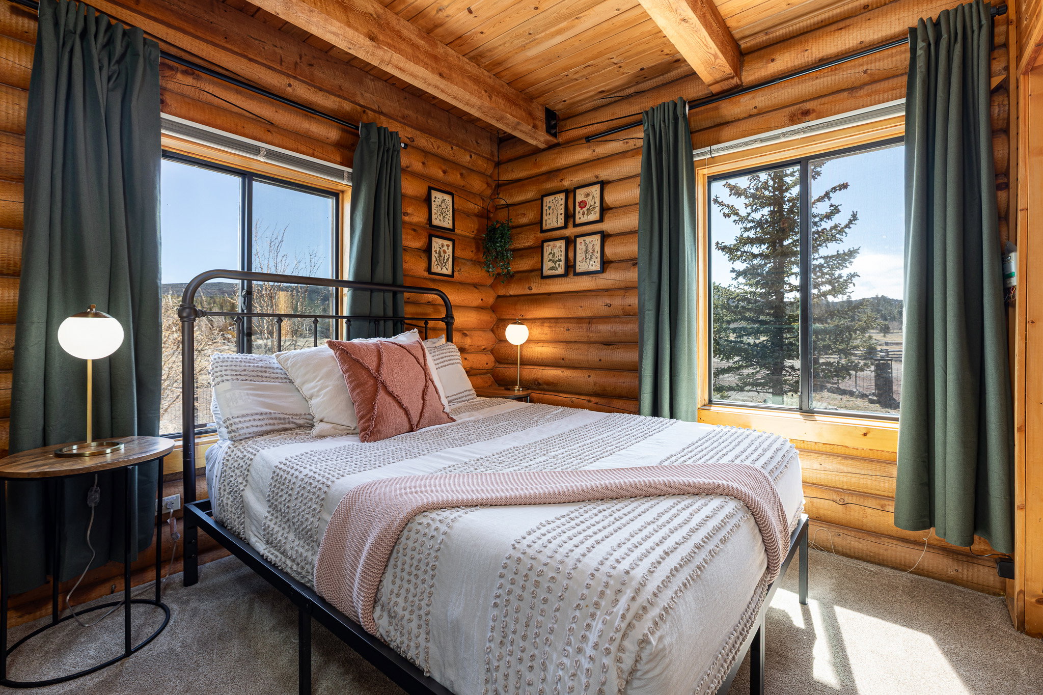 Carpeted bedroom featuring rustic walls and a wood ceiling with exposed beams