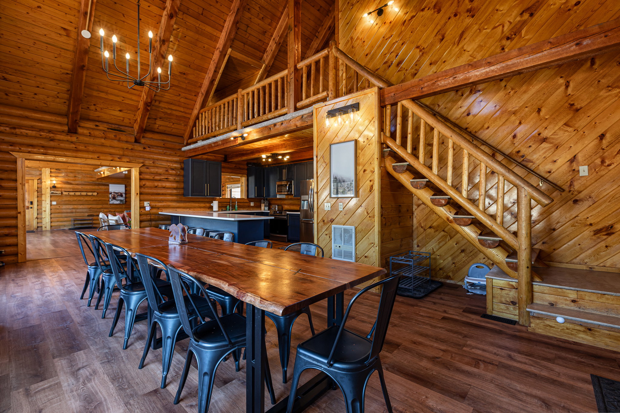 Dining room featuring a high wood beamed ceiling, rustic walls, dark wood-type flooring, and suspended lighting