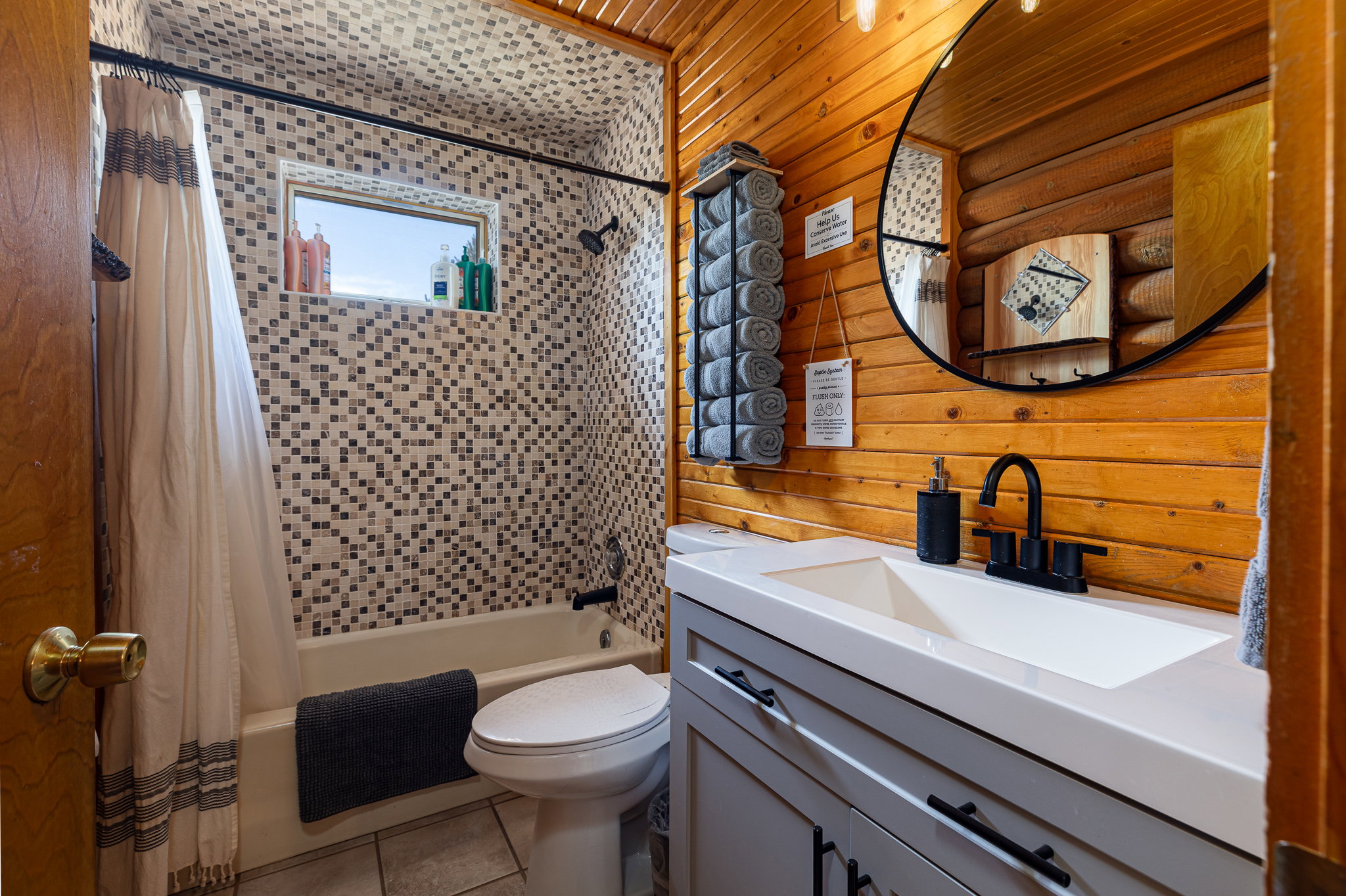 Full bath with shower / bath combo with shower curtain, vanity, wood walls, and light tile patterned flooring