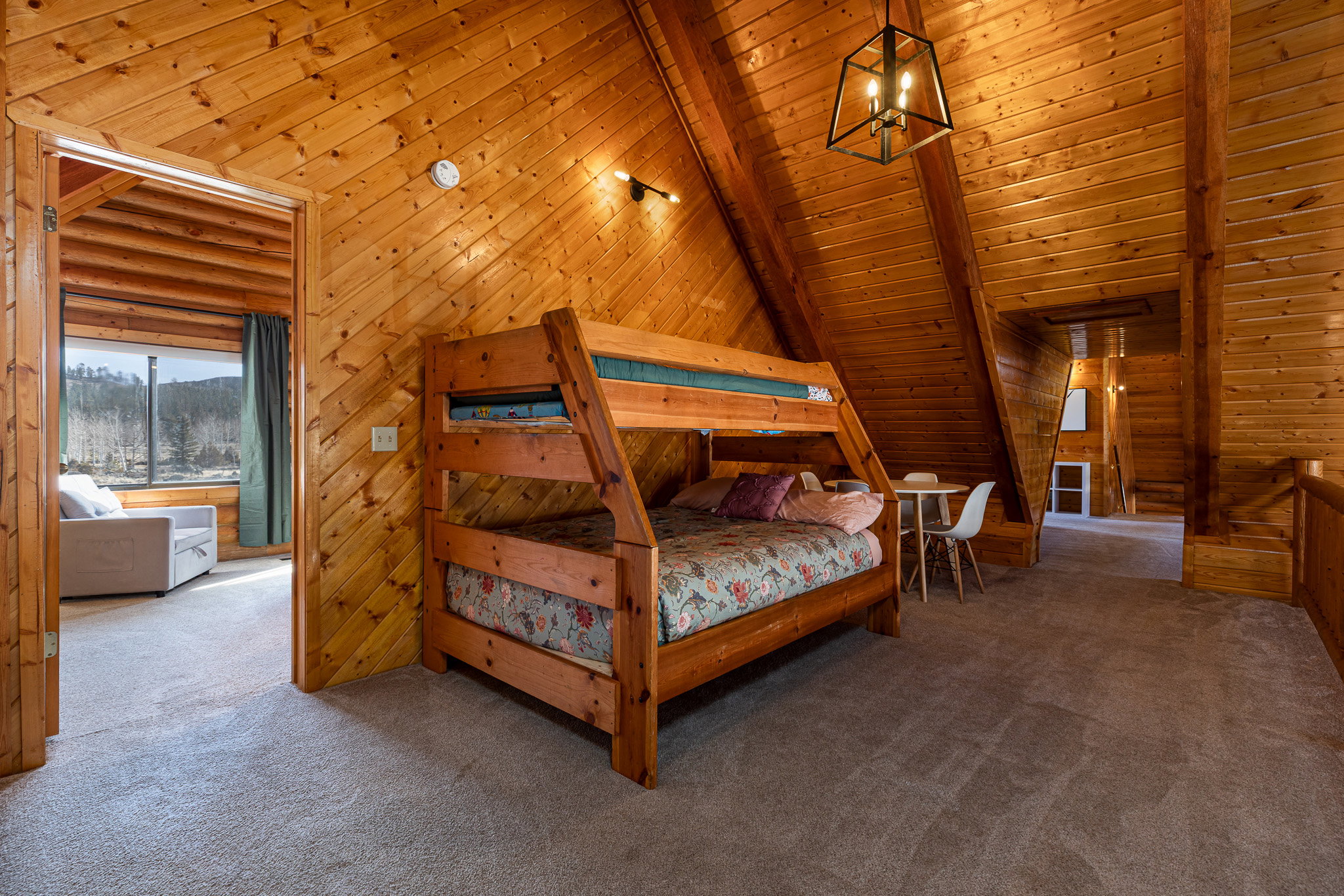 Carpeted bedroom featuring a high wooden beamed ceiling, wooden walls, and rustic walls