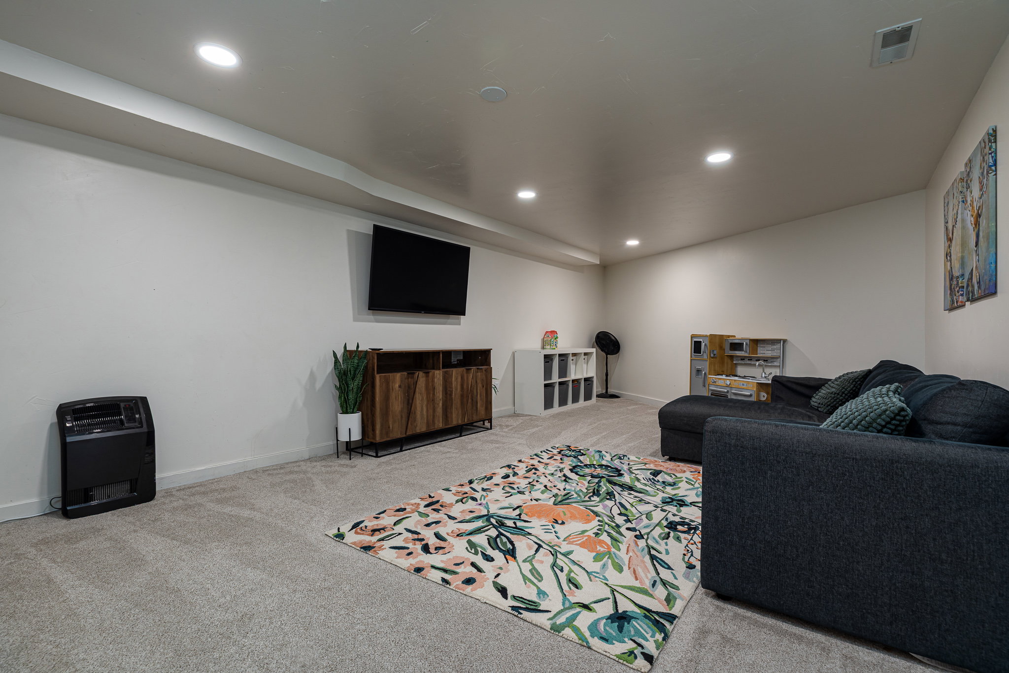 Living area with light carpet and recessed lighting