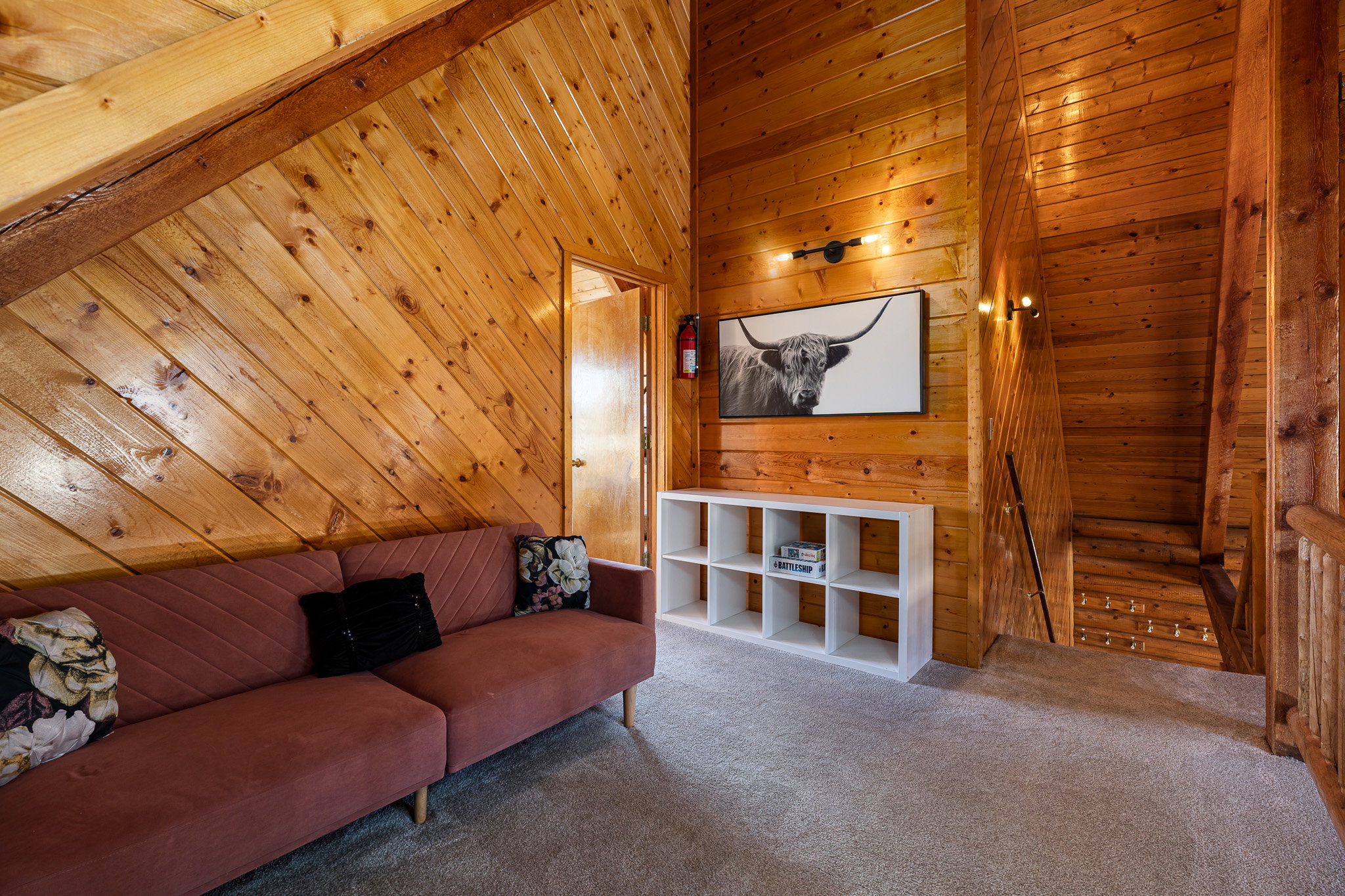 Living area featuring wooden walls and carpet flooring
