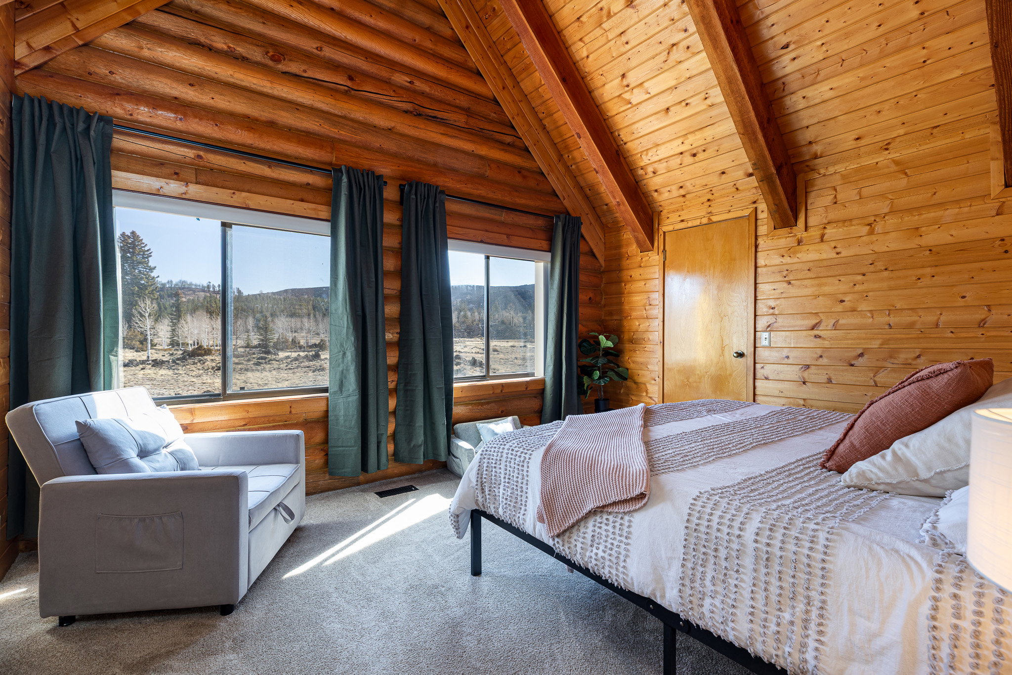 Carpeted bedroom featuring vaulted ceiling with beams, wooden ceiling, and wooden walls