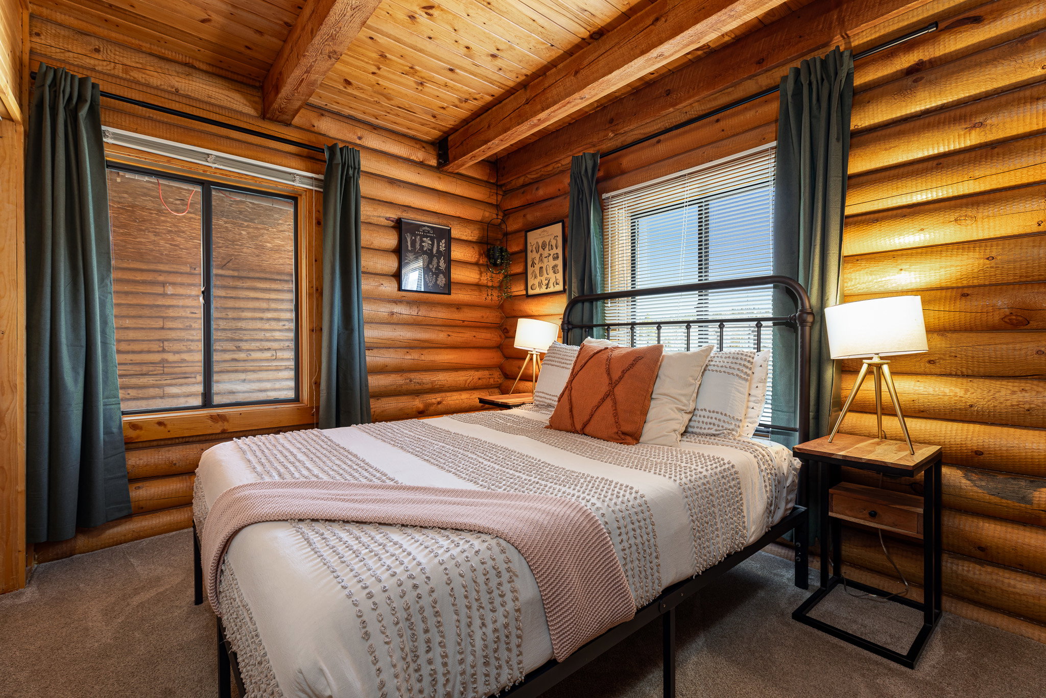 Bedroom featuring log walls, carpet floors, and a wood ceiling with exposed beams