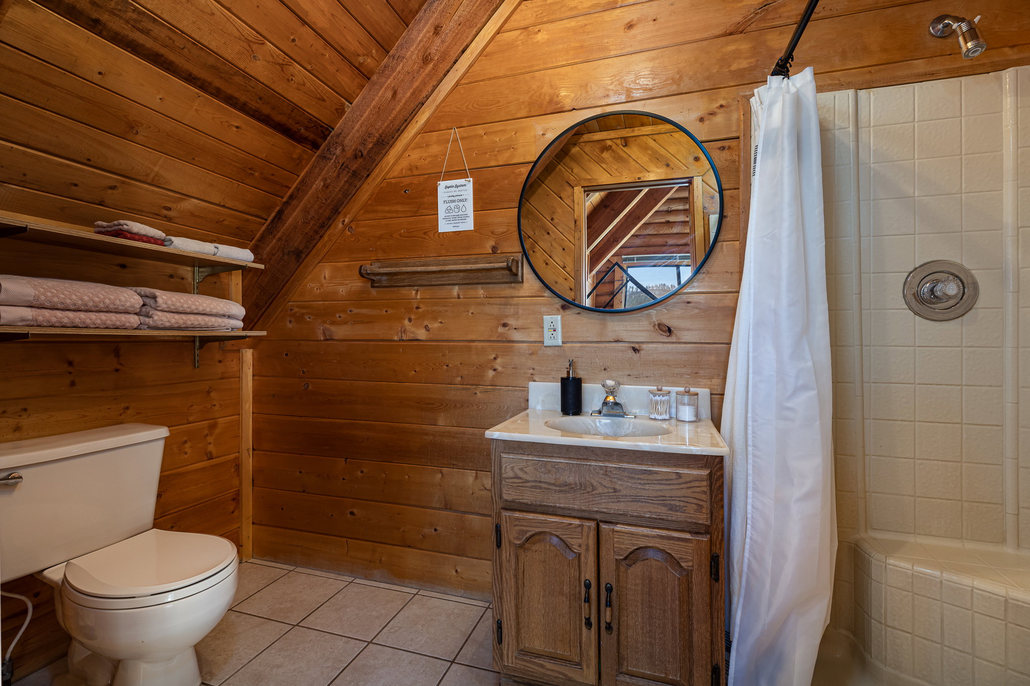Bathroom with vanity, light tile patterned floors, a shower stall, wooden walls, and wooden ceiling
