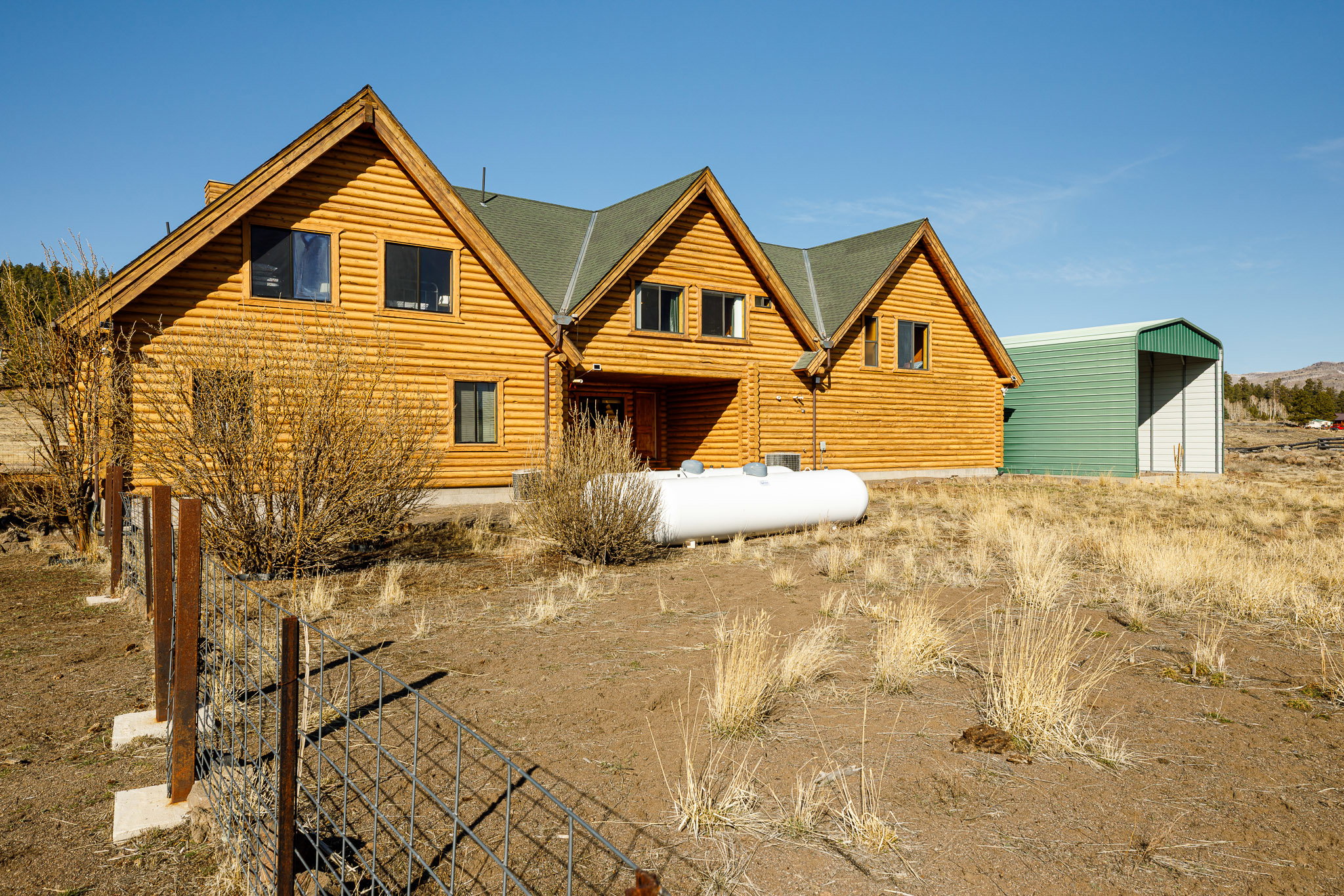 Rear view of house featuring a shingled roof