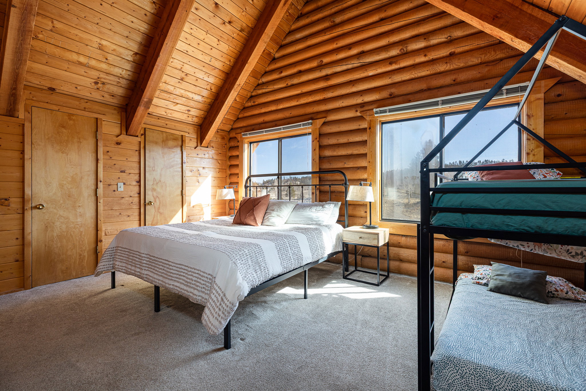 Bedroom featuring carpet, a high wood beamed ceiling, and rustic walls