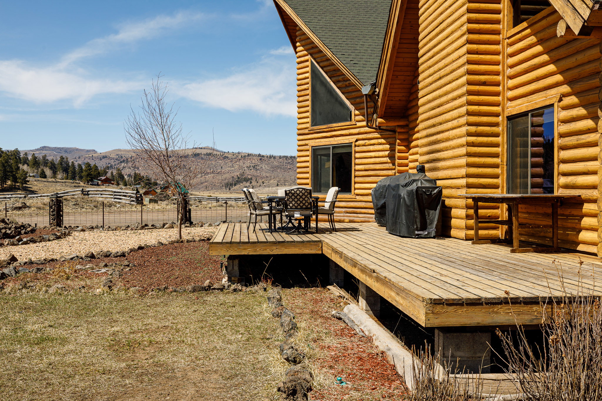 Wooden deck featuring outdoor dining space, a grill, and a mountain view