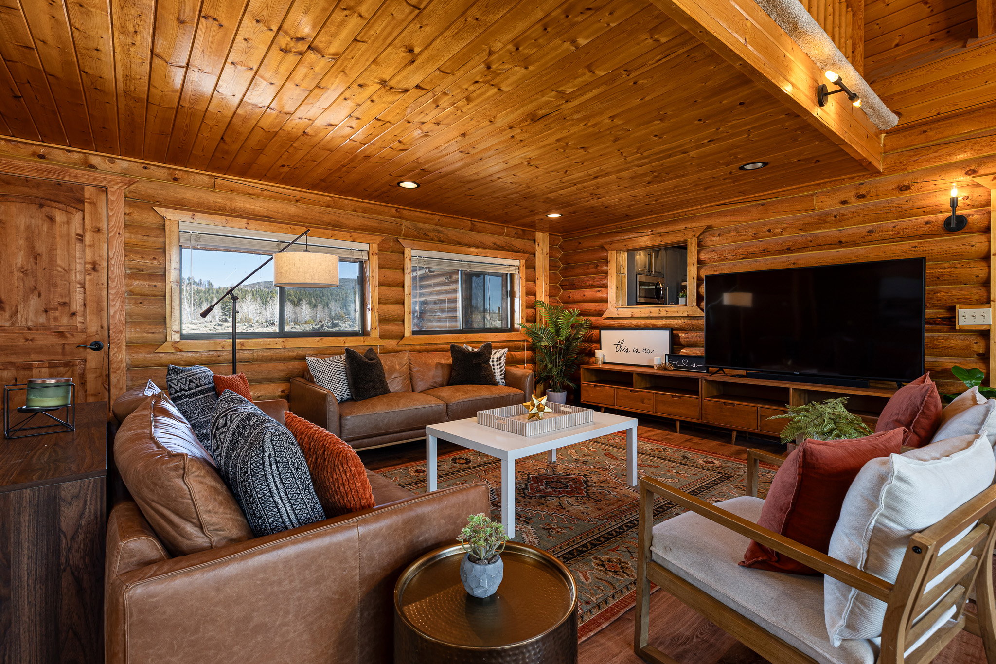 Living room with wood ceiling, log walls, and recessed lighting