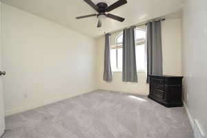Empty room with light carpet, lofted ceiling, and ceiling fan