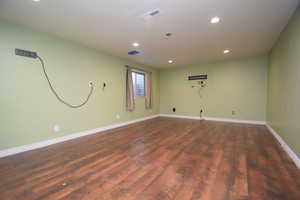 Empty room featuring recessed lighting and dark wood-style flooring