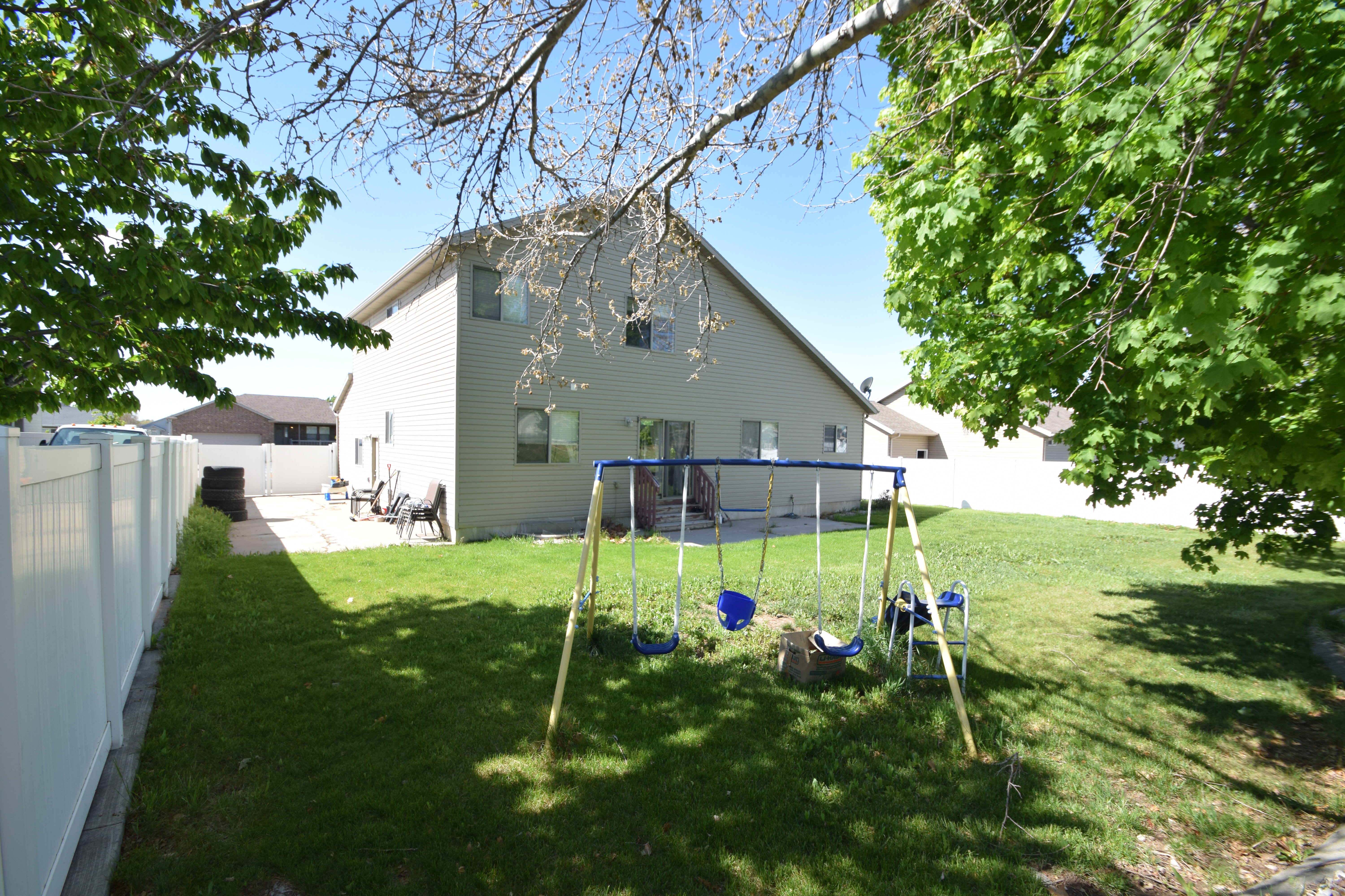Back of house with a playground and a fenced backyard