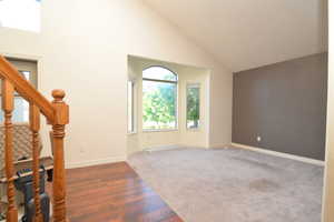 Entrance foyer with lofted ceiling and wood finished floors