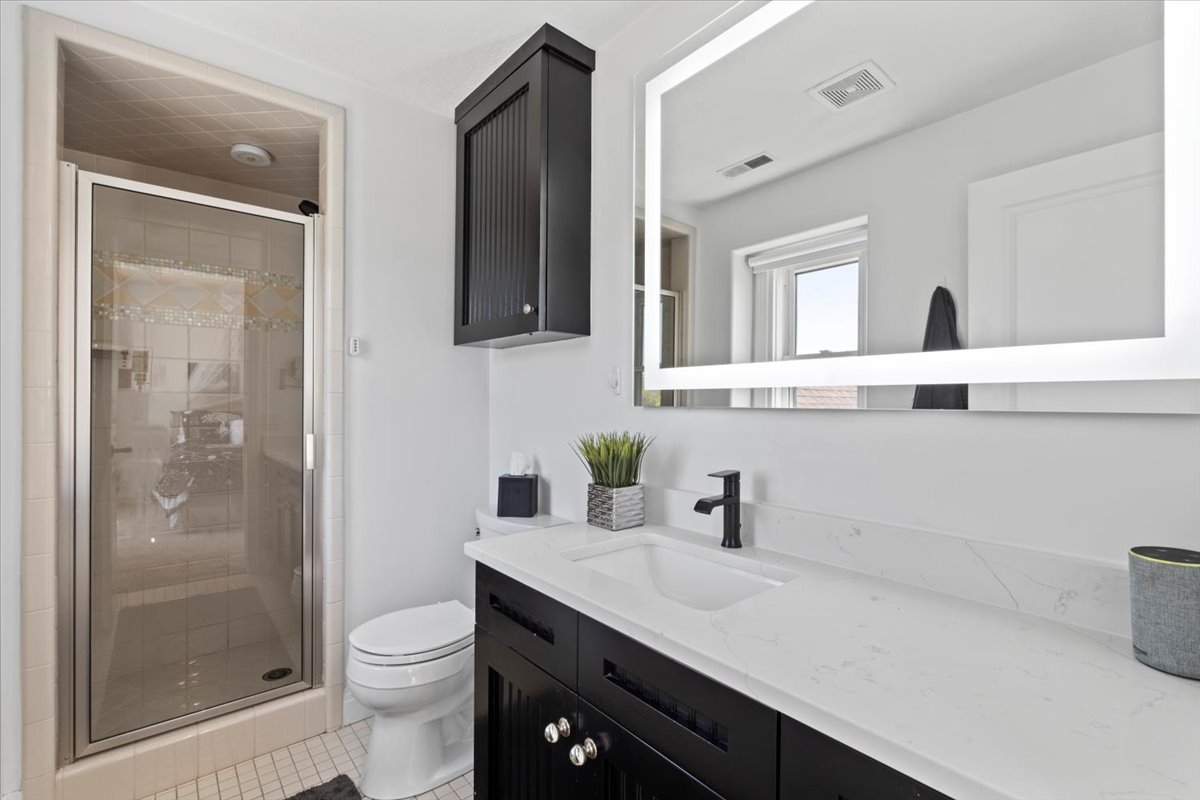 Bathroom featuring a stall shower, vanity, and light tile patterned floors