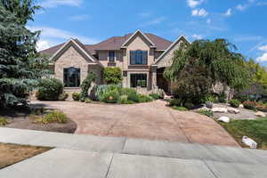 Craftsman inspired home featuring curved driveway, stone siding, and stucco siding
