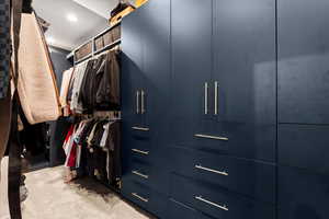 Walk in closet featuring light colored carpet