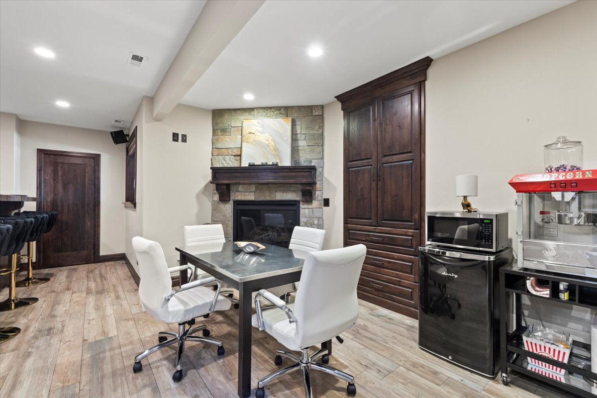 Office space featuring a fireplace, light wood finished floors, and recessed lighting