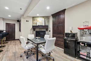 Office space featuring a fireplace, light wood finished floors, and recessed lighting