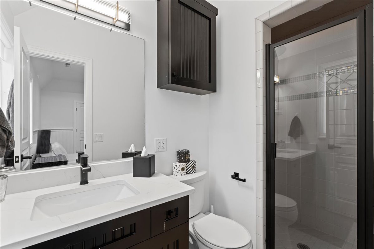 Full bath with vanity, a shower stall, and connected bathroom