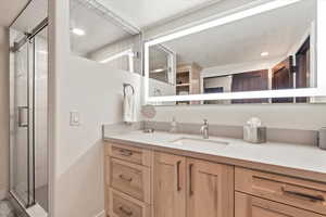Bathroom featuring vanity, a stall shower, and recessed lighting