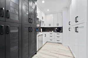 Kitchen featuring white cabinetry, recessed lighting, backsplash, light wood-type flooring, and stainless steel dishwasher