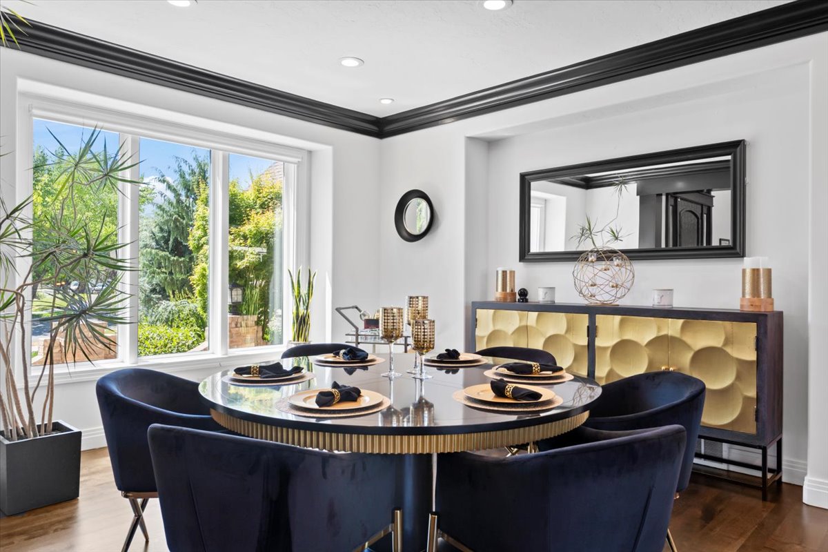 Dining area with dark wood finished floors, crown molding, and recessed lighting