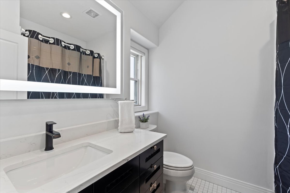 Full bathroom featuring vanity, a shower with shower curtain, and light tile patterned flooring