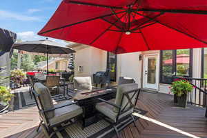 Wooden terrace featuring outdoor dining area, area for grilling, and an outdoor fire pit