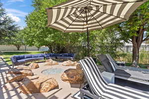 Fenced backyard featuring an outdoor living space with a fire pit and a patio