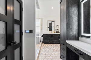 Bathroom with a freestanding tub, vanity, recessed lighting, and light tile patterned floors